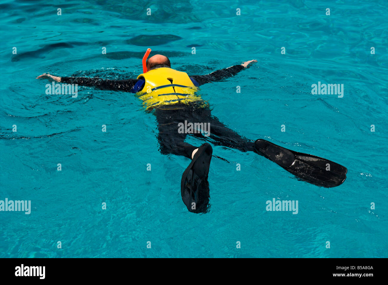 Man snorkeling in sea wearing life vest Bahamas Stock Photo