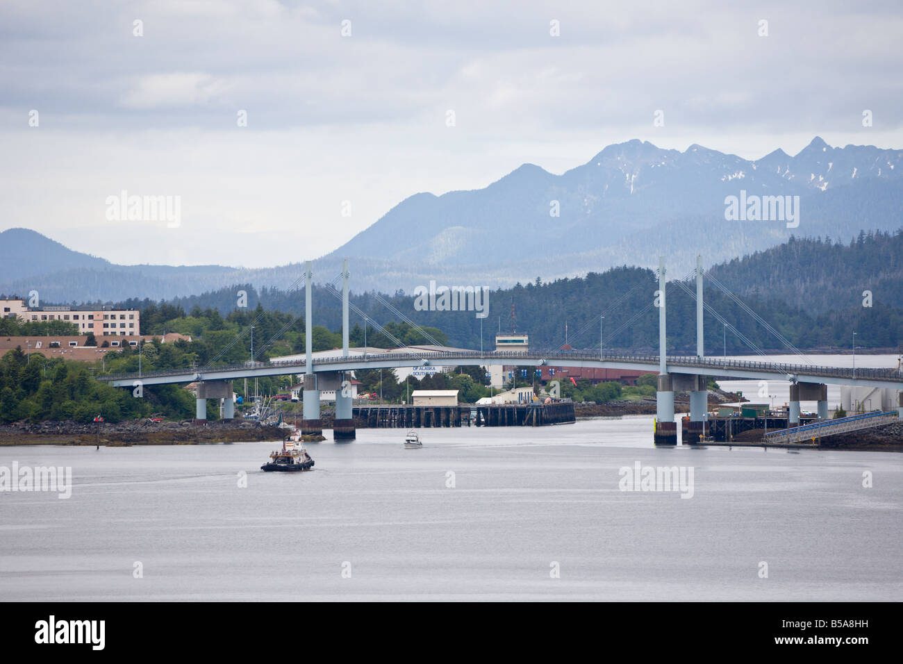 Tugboat and fishing boat passing under Harbor Road bridge separating East Channel and West Channel in Sitka, Alaska Stock Photo