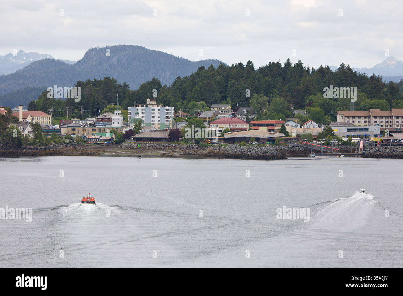 Cruise ship tender boat approaches shoreline of Sitka, Alaska Stock Photo