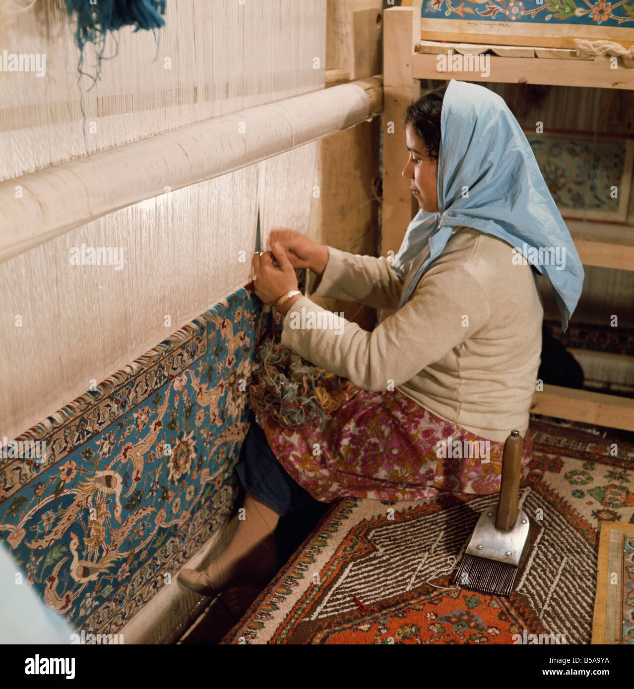 Woman weaving carpet on loom Iran Middle East R Ashworth Stock Photo
