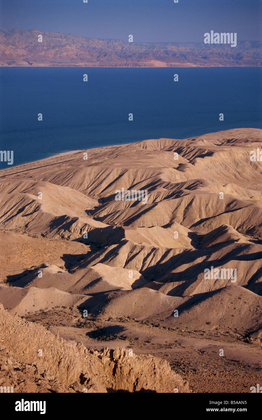 Arid hills on shore of Dead Sea, with Jordanian Mountains in the background, Israel, Middle East Stock Photo