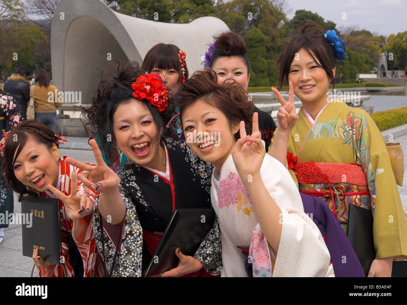 Group of female students in kimonos laughing at the camera, Cenotaph, Peace Memorial Park, Hiroshima, Honshu, Japan Stock Photo
