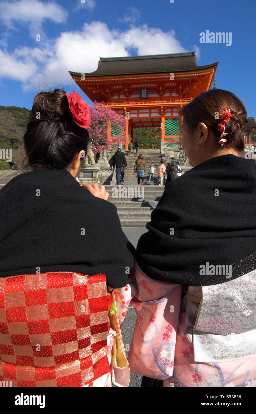 Two women in traditional kimonos walking towards the main entrance torii, Kiyomizudera temple, Kyoto, Kansai, Honshu, Japan Stock Photo