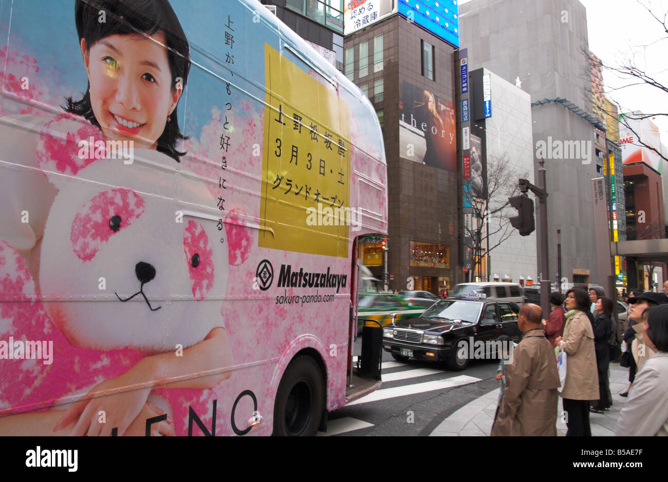 Double decker bus used for advertising of department store in foreground, Ginza, Tokyo, Honshu, Japan Stock Photo