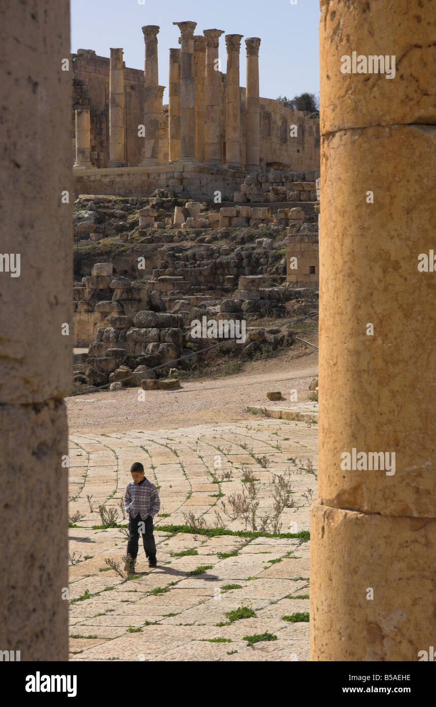 View through columns of boy walking past, Jerash, Jordan, Middle East Stock Photo