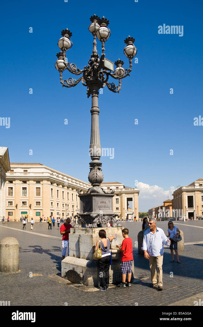 Streetlamp and tourists in Saint Peter’s Square, Piazza San Pietro, Vatican City, Rome, Italy Stock Photo