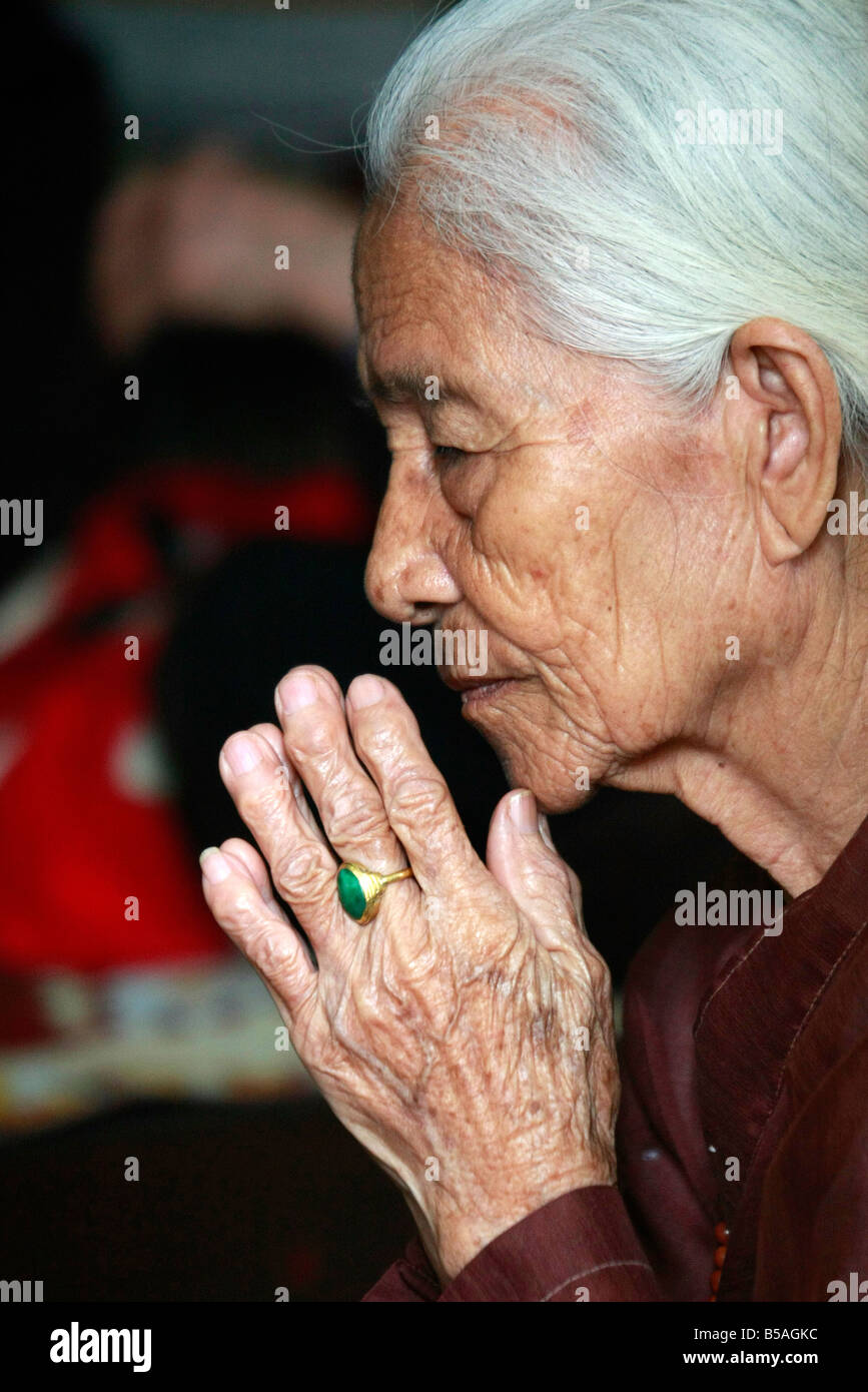 Vietnamese woman in prayer at the Dien Huu Pagoda, Hanoi, Vietnam Stock