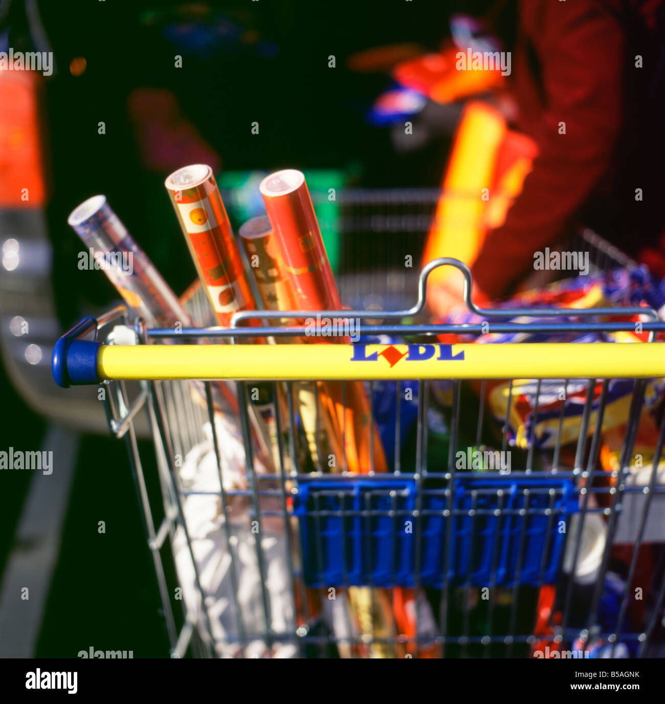 Rolls of Christmas wrapping paper in a Lidl shopping cart outside the