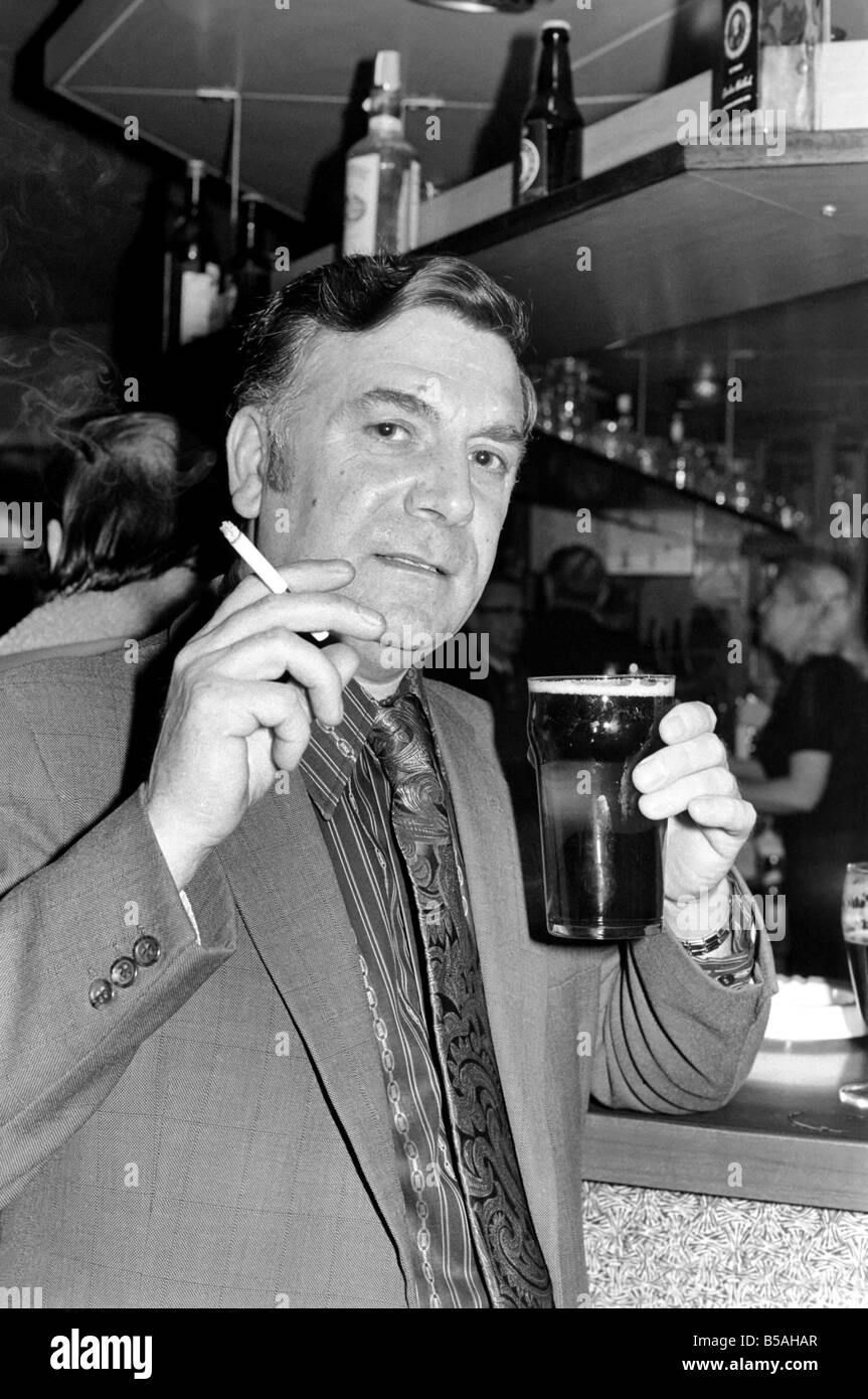 Andy Bradley enjoying his pint and a fag in the local before the chancellor puts up the tax on alcohol and tobacco in the budget. April 1975 Stock Photo