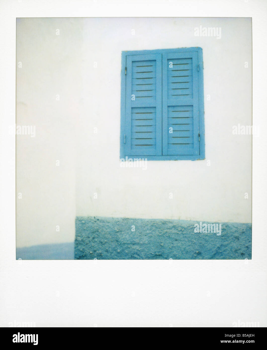 Polaroid of painted blue window shutter against whitewashed wall Asilah Morocco North Africa Africa Stock Photo