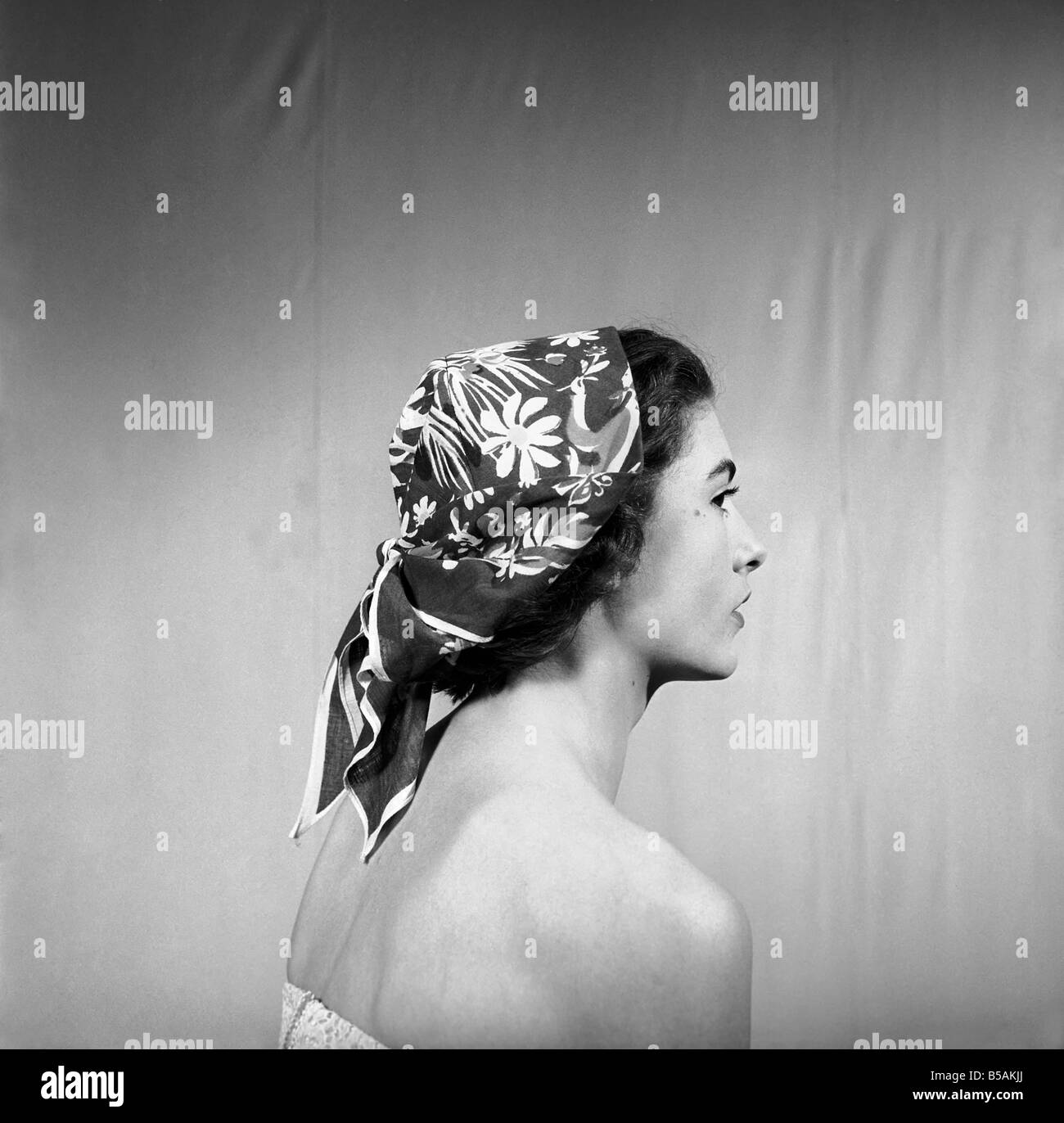 Woman modeling several ways of wearing a head scarf. April 1953 Stock