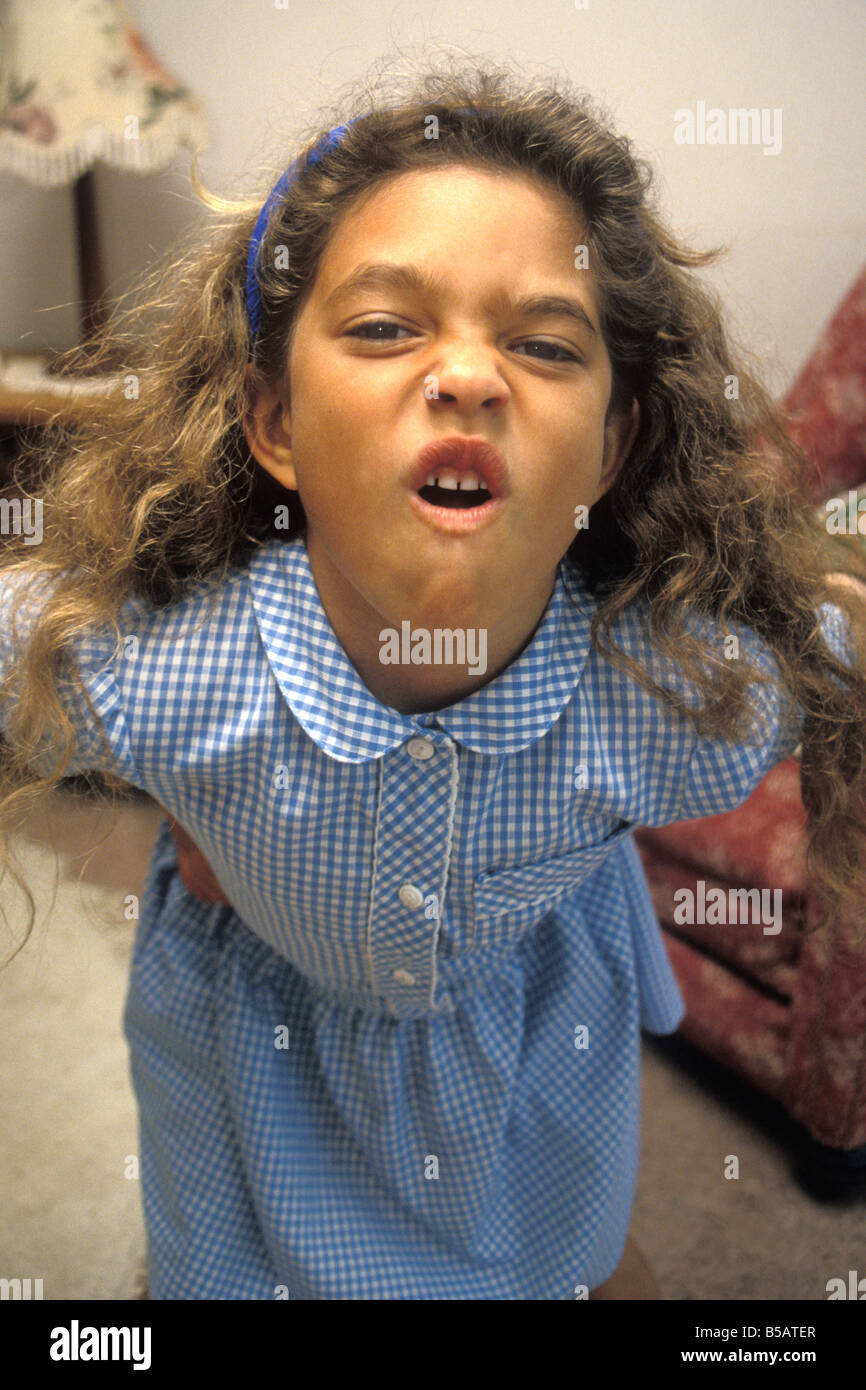 precocious schoolgirl pulling rude face into camera Stock Photo