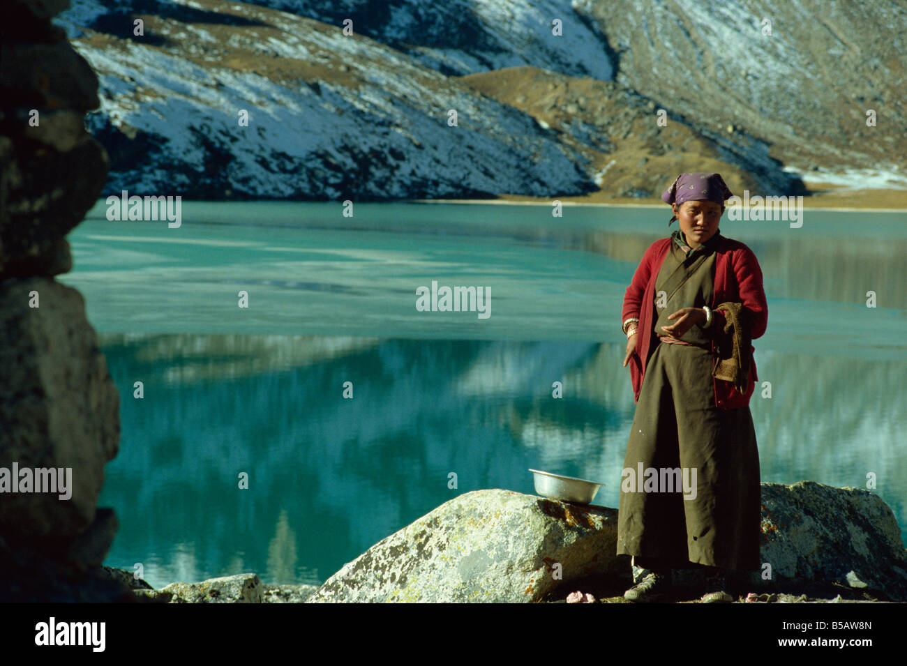 Female porter at Gokyo Lake at 4750m frozen in early morning Khumbu Himal Nepal Asia Stock Photo