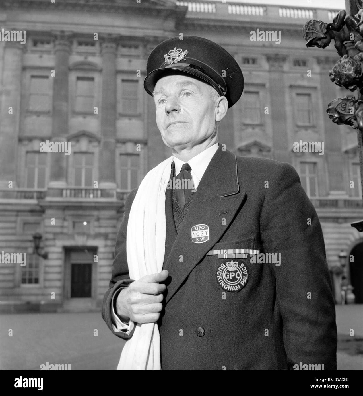The Royal Postman stands at the gates to Buckingham Palace before collecting Queen ElizabethÍs mail. 1957 A874-003 Stock Photo