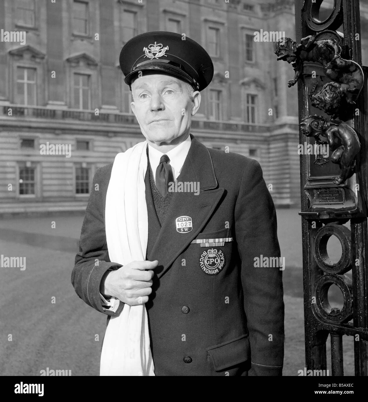 The Royal Postman stands at the gates to Buckingham Palace before collecting Queen ElizabethÍs mail. 1957 A874-004 Stock Photo