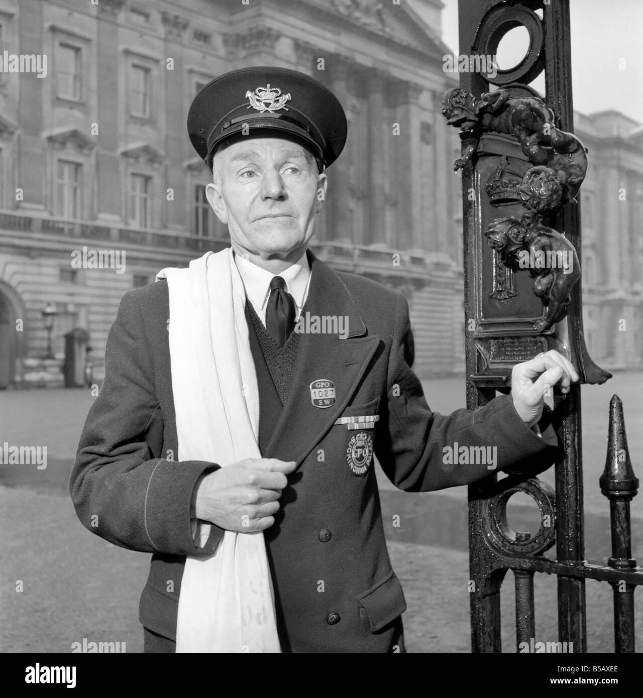 The Royal Postman stands at the gates to Buckingham Palace before collecting Queen ElizabethÍs mail. 1957 A874-005 Stock Photo