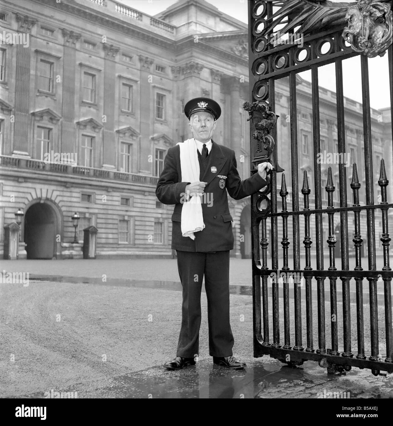 The Royal Postman stands at the gates to Buckingham Palace before collecting Queen ElizabethÍs mail. 1957 A874-006 Stock Photo