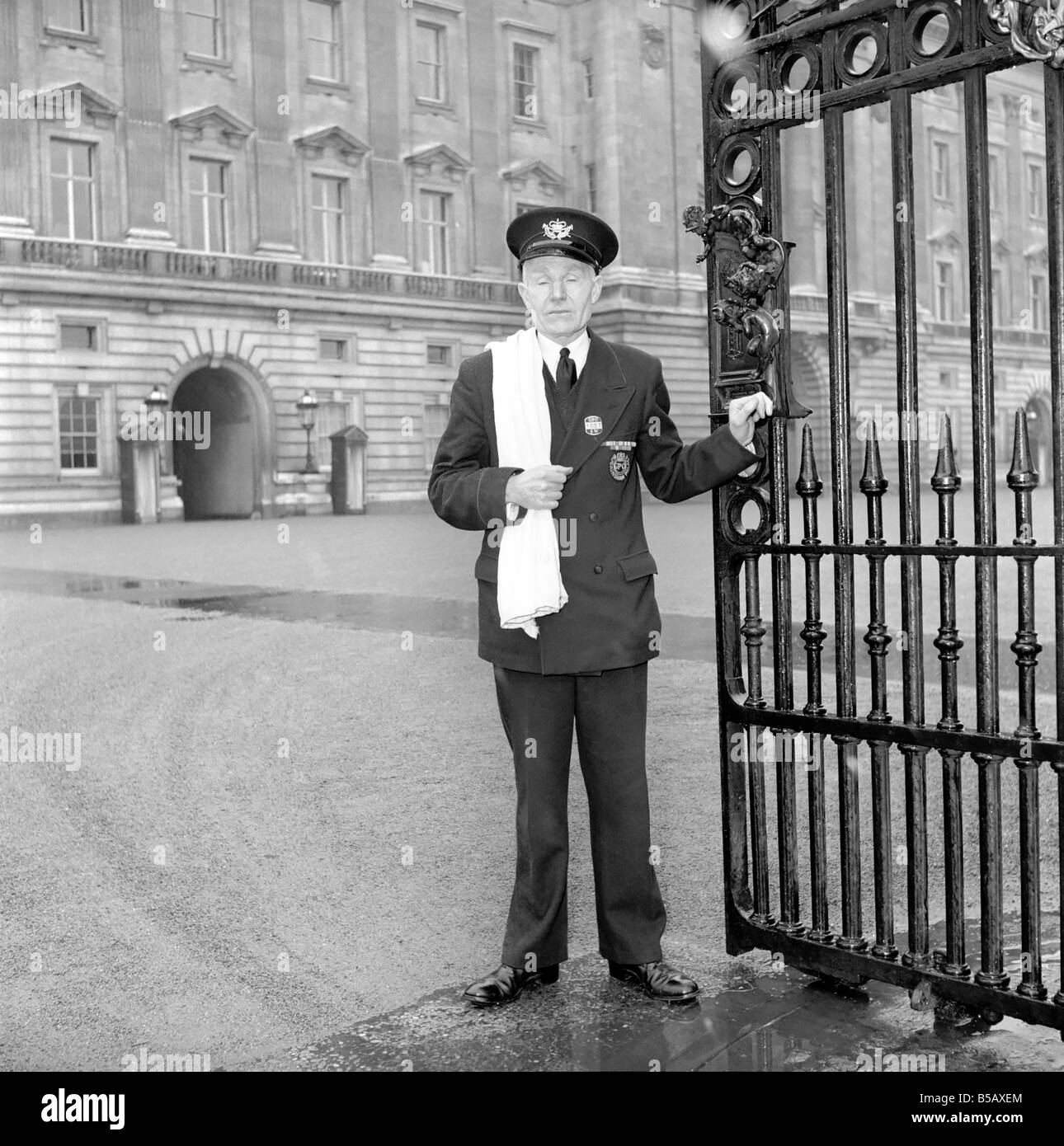 The Royal Postman stands at the gates to Buckingham Palace before collecting Queen ElizabethÍs mail. 1957 A874-007 Stock Photo