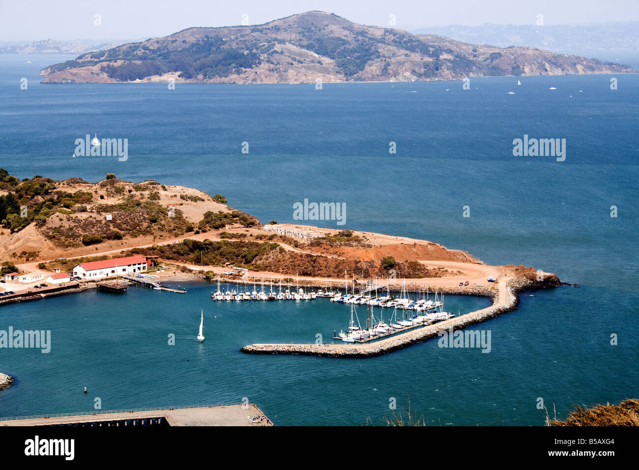 Small wharf in calm water with an island in the background near the Golden Gate bridge in San Francisco, California Stock Photo