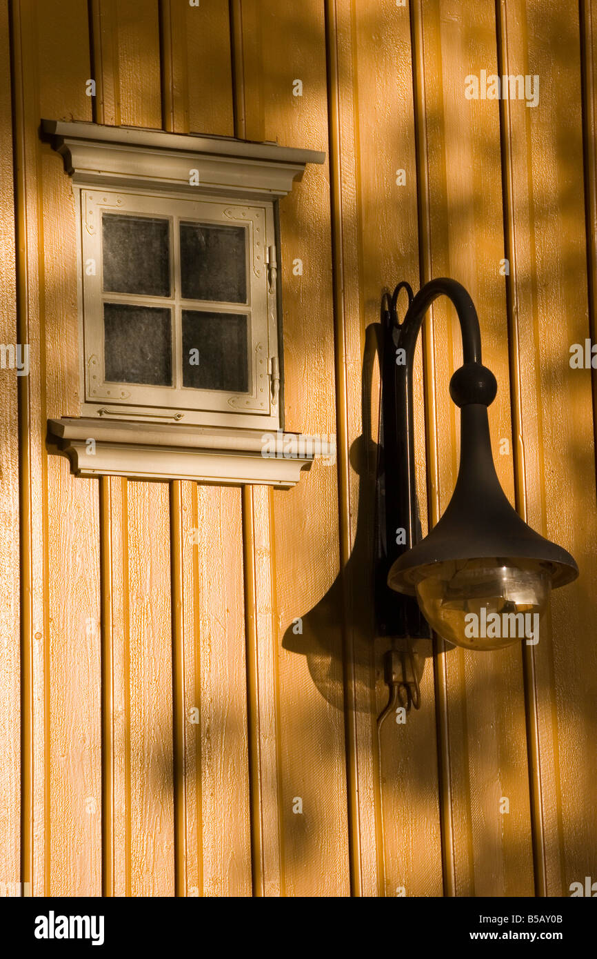 The late day summer sun casts its light on a window and lamp in the old town of Gamlebyen in Fredrikstad Norway, south of Oslo. Stock Photo