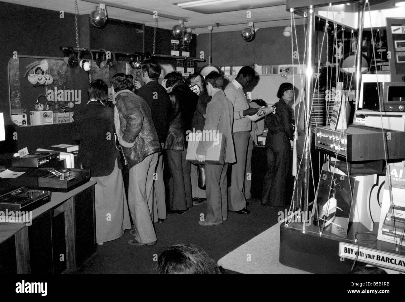 Beat the Budget shopping spree in Tottenham Court Road, London, street of radio and Hi-fi. ;Customers looking at goods in an electrical store;April 1975 ; Stock Photo