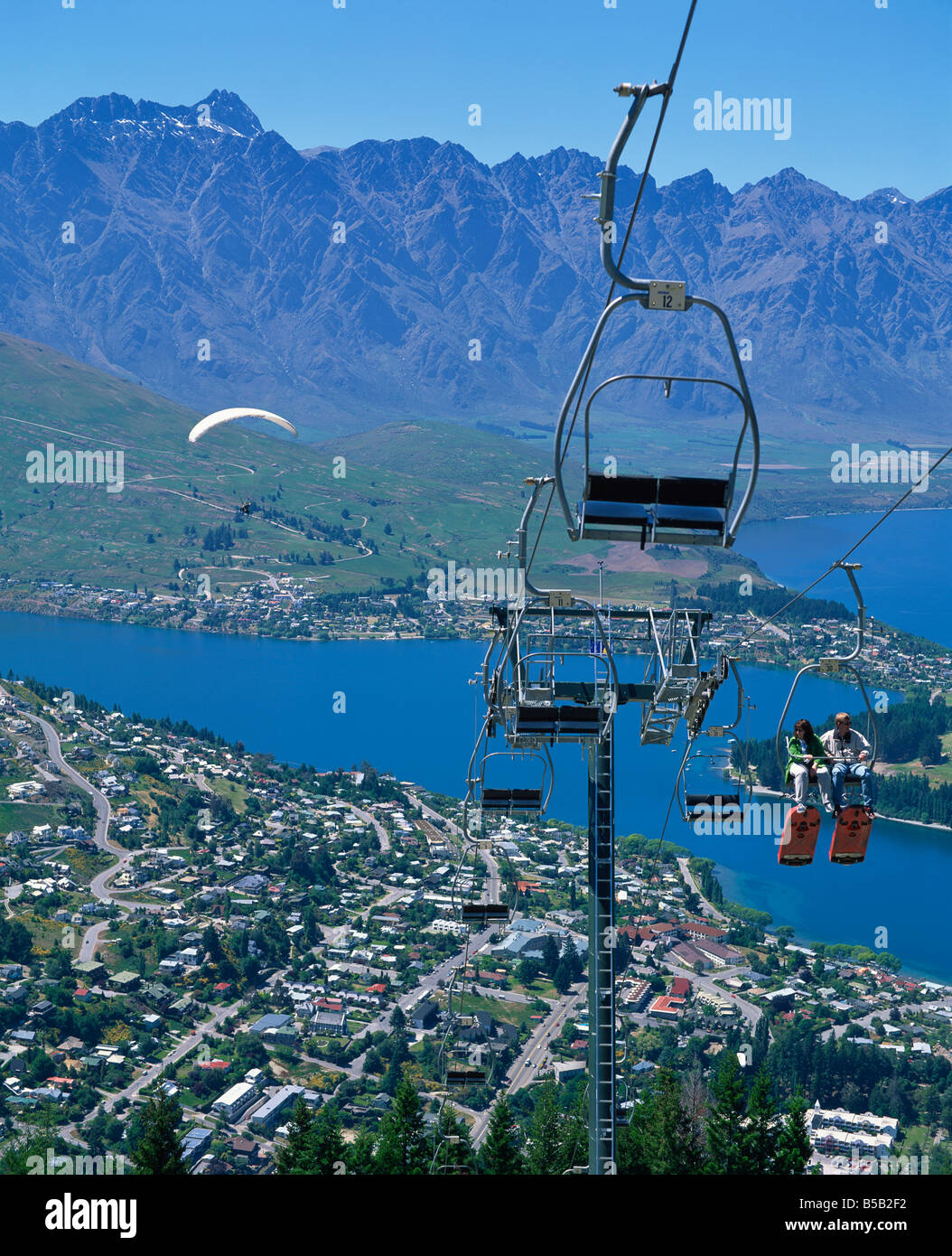 Tourists on a chair lift with Lake Wakatipu the Remarkable Mountains