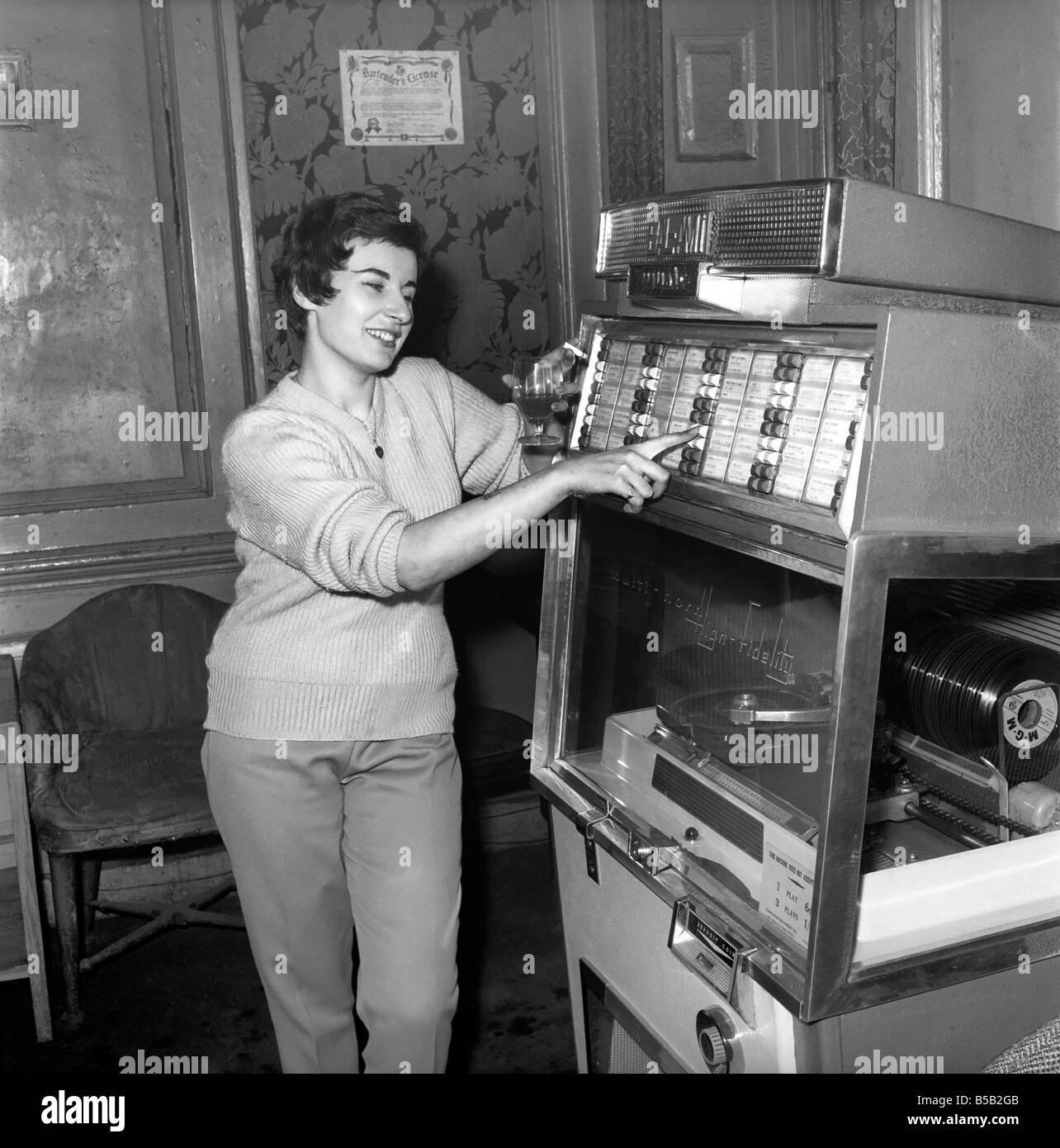 Woman selected tracks from juke box. 1960 Stock Photo