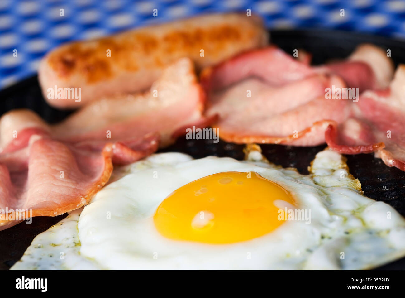 Fried egg bacon and sausage in frying pan close up Stock Photo Alamy