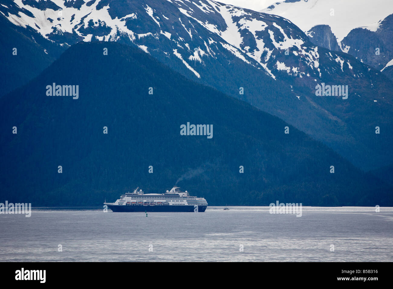 Cruise ship sailing the Inside Passage between Seattle and Alaska in front of snow capped mountains Stock Photo