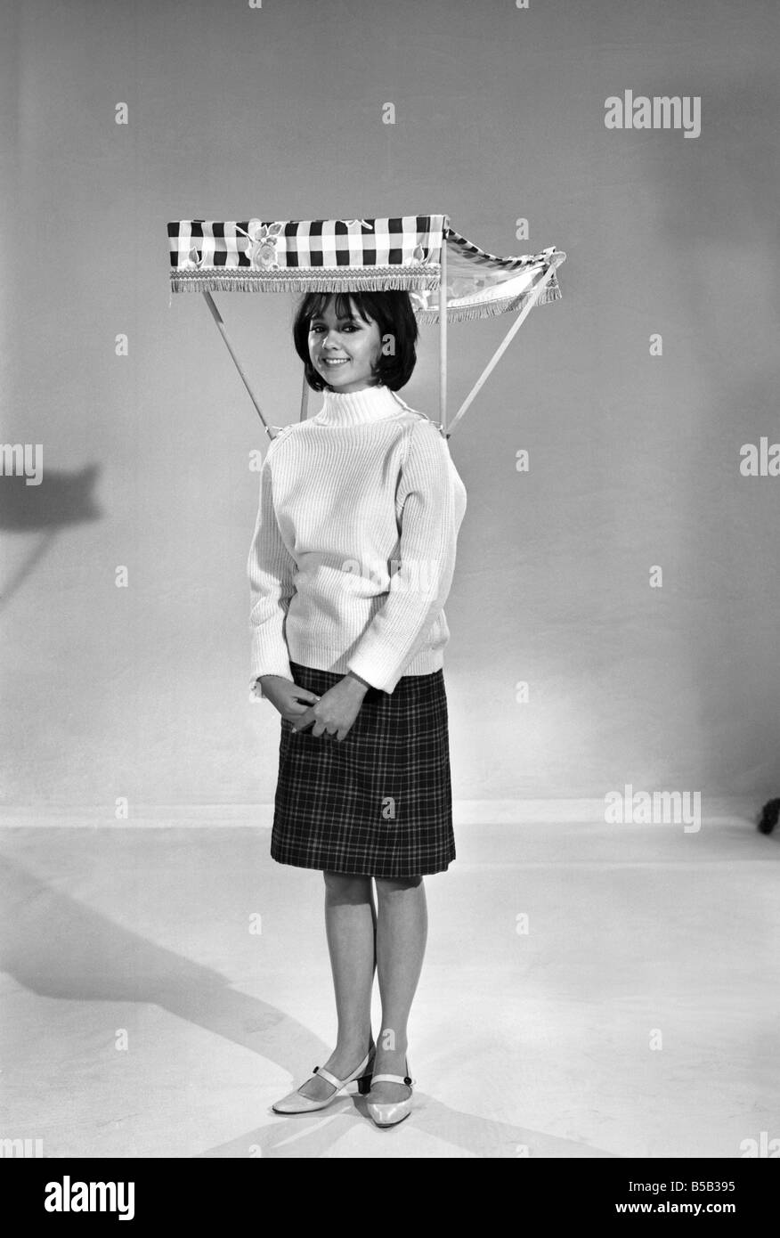 Therese Howard Jones demonstrating the wear-me umbrella. Model . Circa 1959 Stock Photo