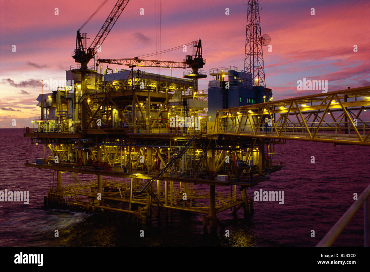 Oil rig illuminated at dusk Gulf of Thailand Advertasia Stock Photo