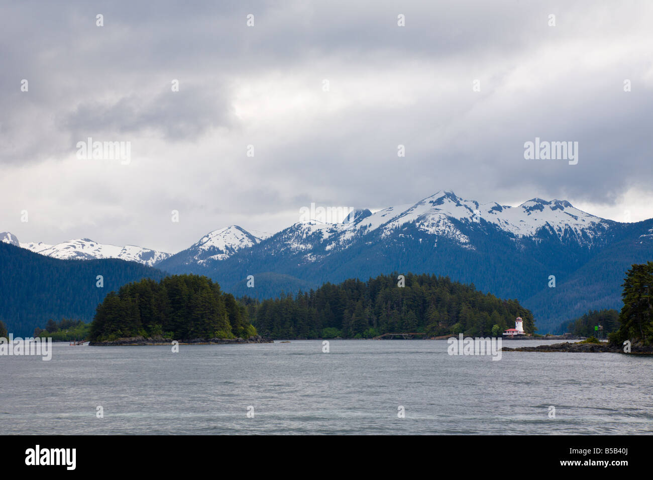 Lighthouse in front of snow capped mountains on island in Eastern Channel of the Inside Passage at Sitka, Alaska Stock Photo
