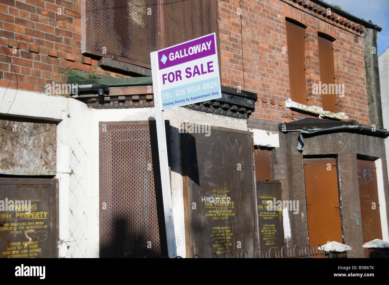 Derelict houses for sale in the Shankill Road area of Belfast Stock Photo