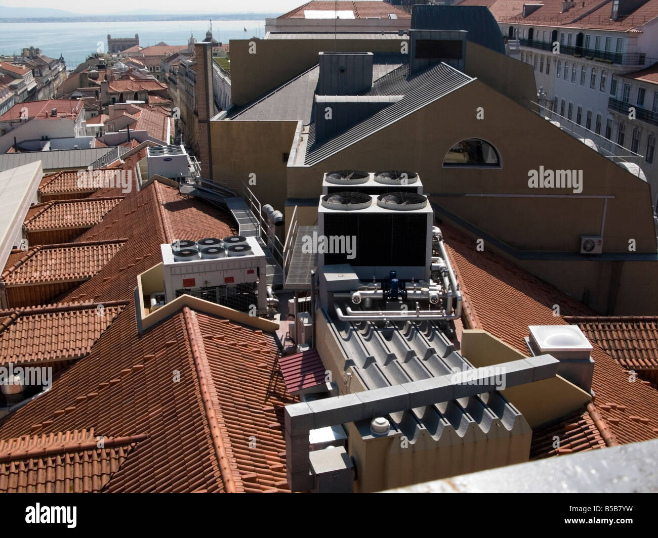 Large modern air conditioning units on traditional red tiled roofs in Lisbon, Portugal Stock Photo