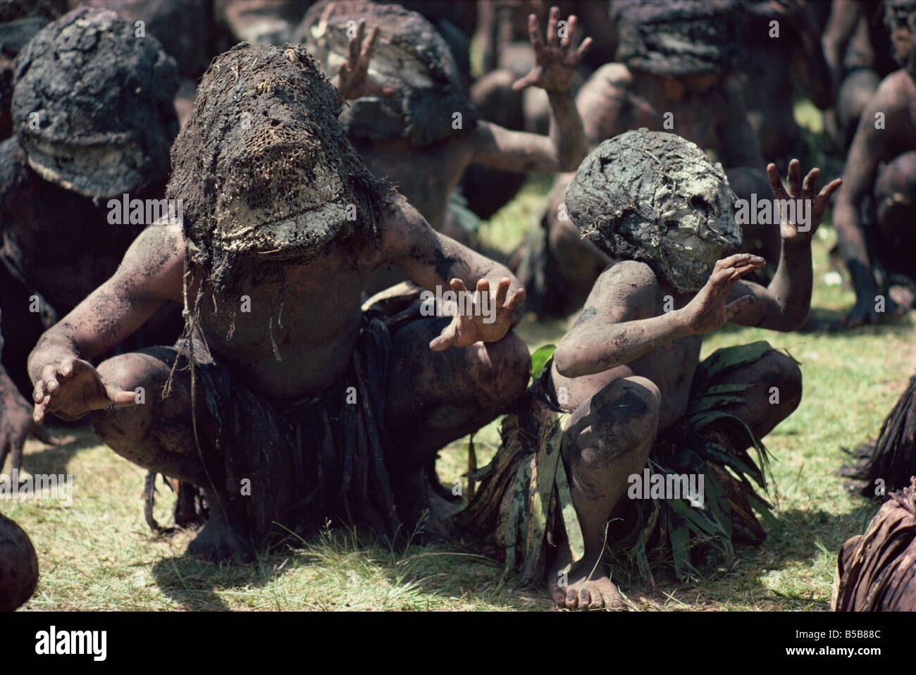Mud men wearing clay masks perform ritual dance Asaro Valley Papua