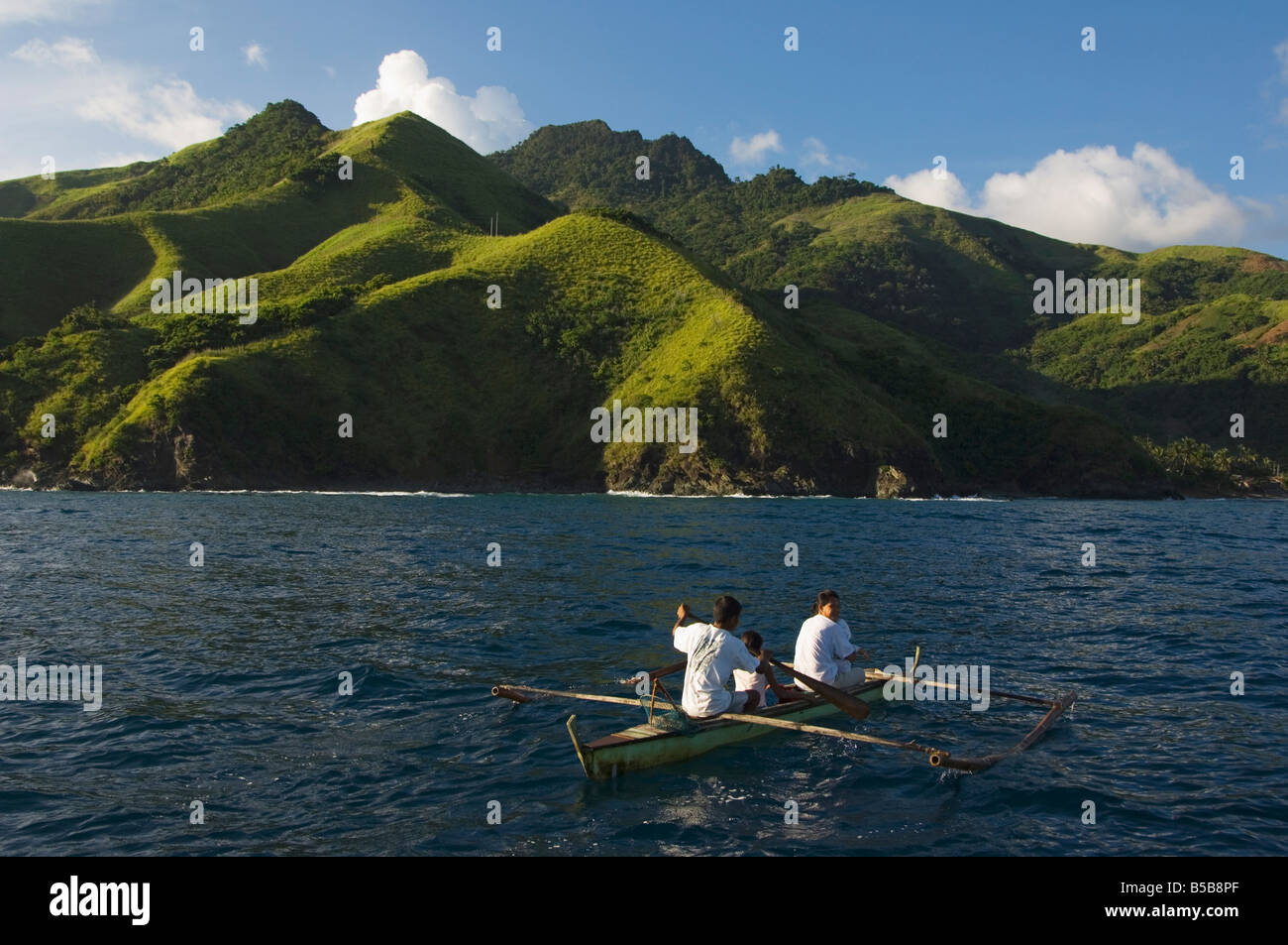 Spectacular coastal scenery and small fishing boat, Camarines Sur, Caramoan National Park, Bicol Province, Philippines Stock Photo
