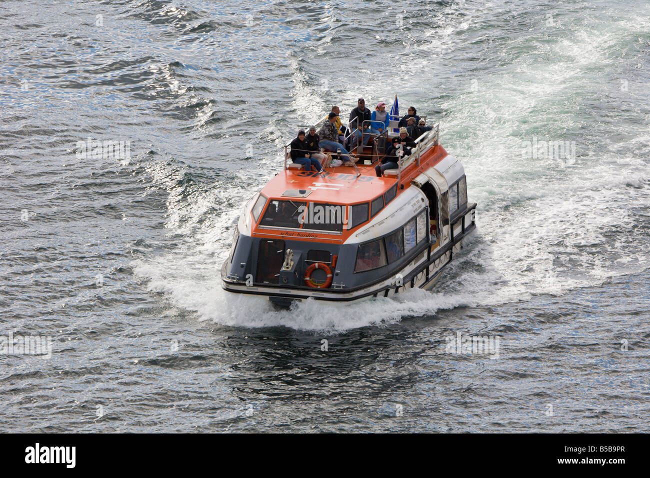 Tender boat carries passengers from shore to cruise ship in the Eastern Channel at Sitka, Alaska Stock Photo