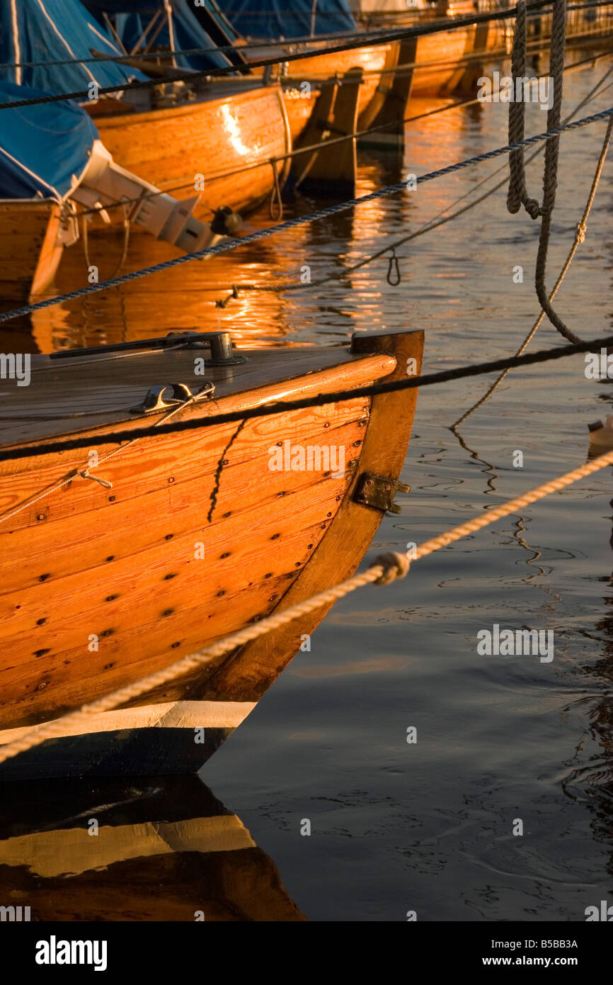 The summer sun casts its light on some wooden boats in the river Glomma near the town of Fredrikstad Norway Stock Photo