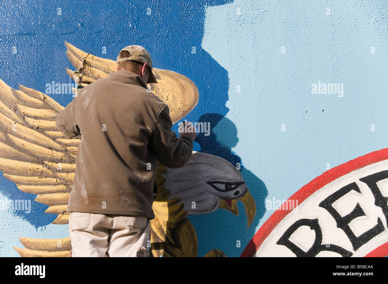 Man on ladder painting a protestant mural off the Shankill Road, Belfast Stock Photo