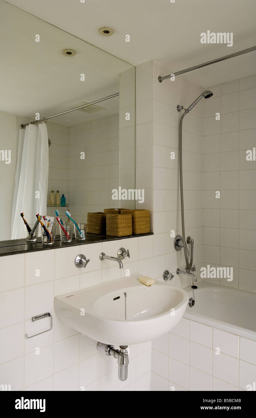 Tiled white bathroom with mirror, bath and shower Stock Photo