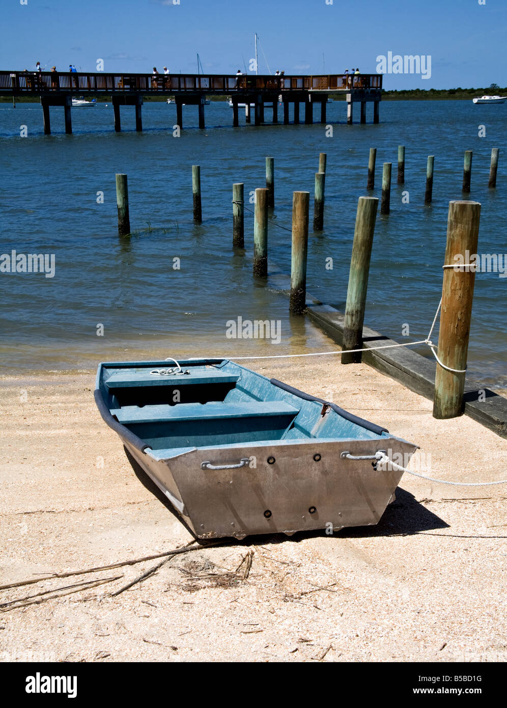 Boat by wooden pilings near a calm bay in St. Augustine, Florida Stock Photo