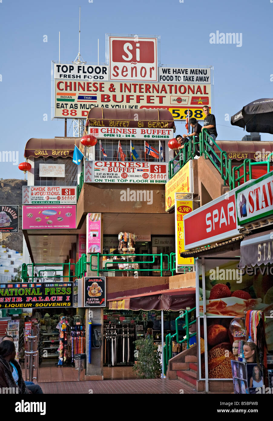 Signs in English in tourist shopping centre including Chinese food and tattoo piercing Gran Canaria Spain Stock Photo