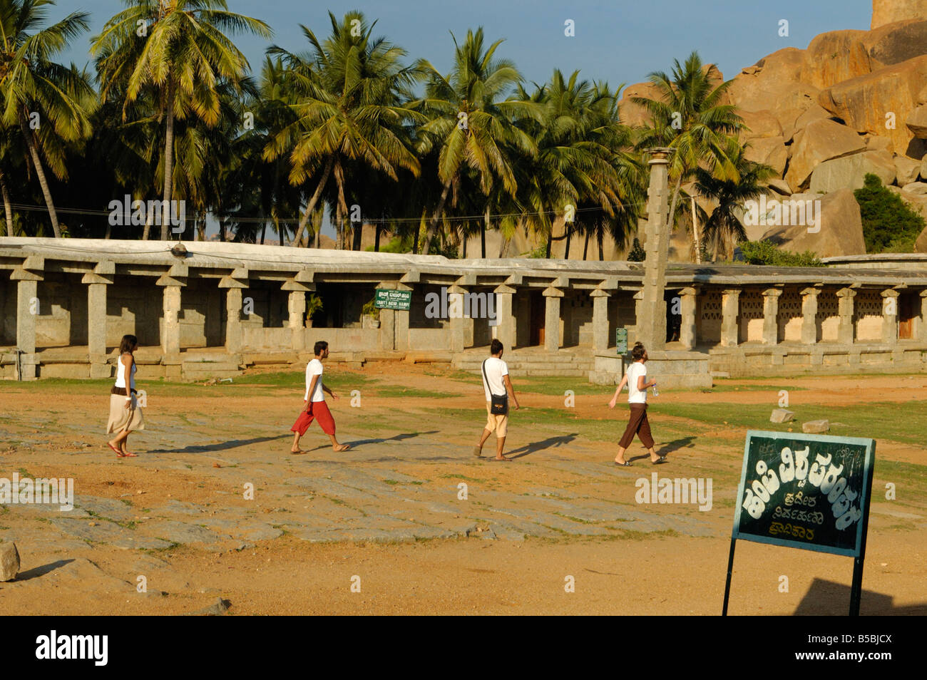 Group of tourists walking along the beautiful Bazaar Street in Hampi with its colonnades. India, Karnataka, Hampi. Stock Photo