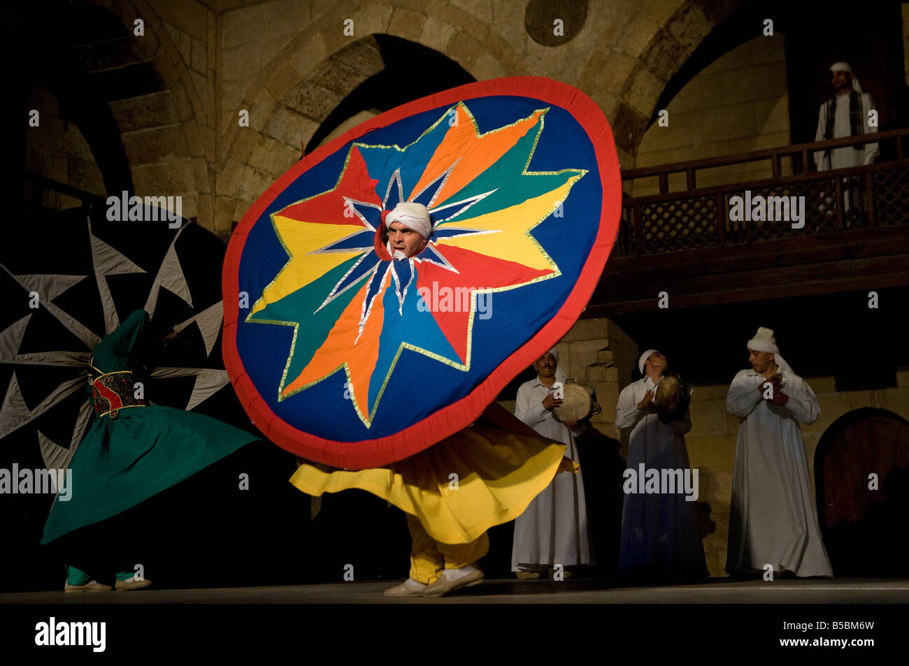 Whirling Dervish or Darvish performance of al tannoura Egyptian heritage dance troupe at the Wekalet el Ghouri Arts Center in Old Cairo Egypt Stock Photo