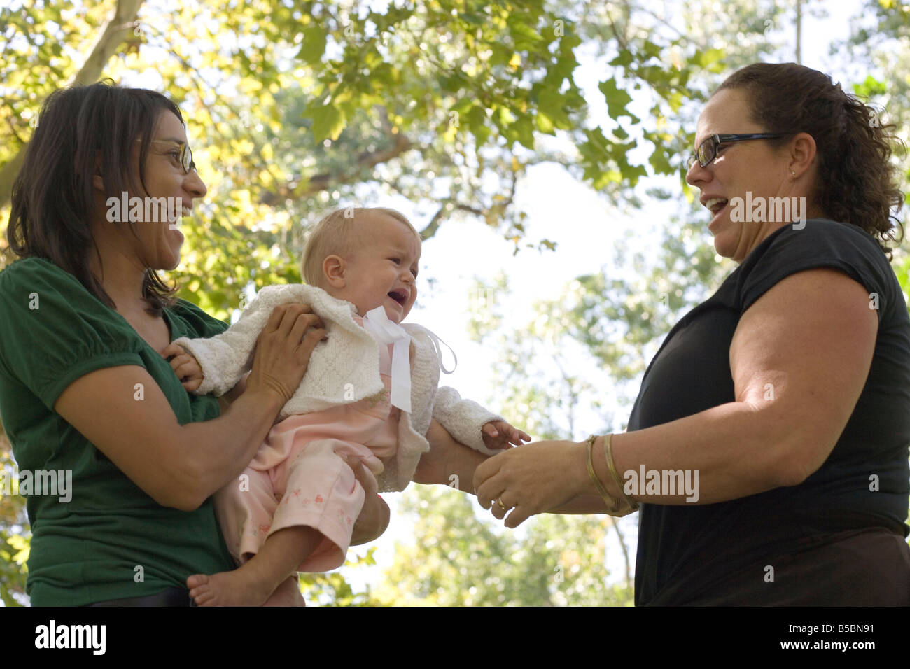 baby girl crying in fear when stranger attempts to hold her, outdoors, southwestern united states Stock Photo
