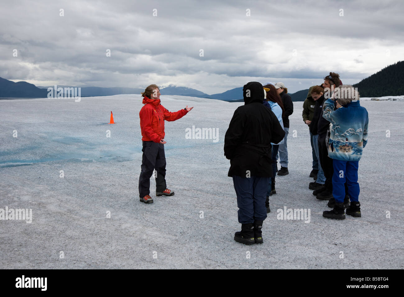 Tour guide on top of Mendenhall Glacier near Juneau Alaska teaches and entertains tourists. Stock Photo