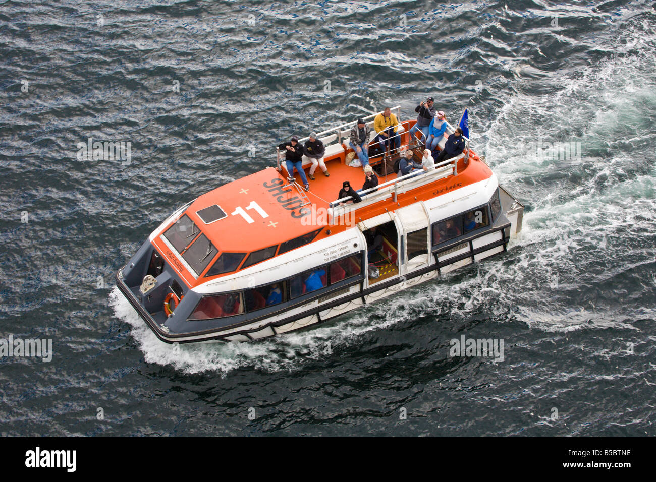 Tender boat carries passengers from shore to cruise ship in the Eastern Channel at Sitka, Alaska Stock Photo