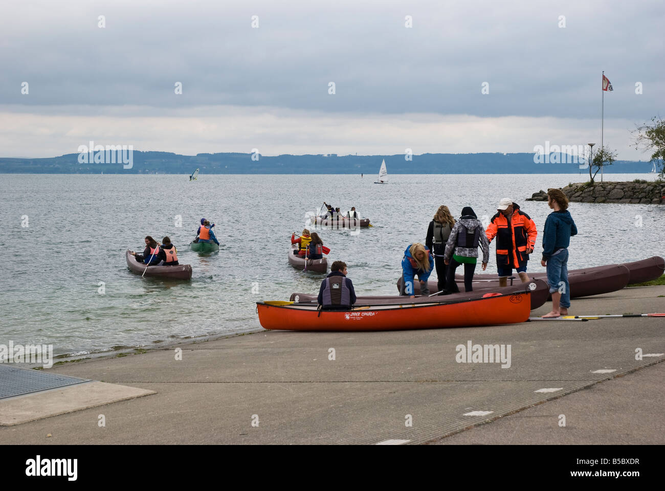 A group of young adult tourists set off on a canoe trip around Lake Neuchatel Stock Photo