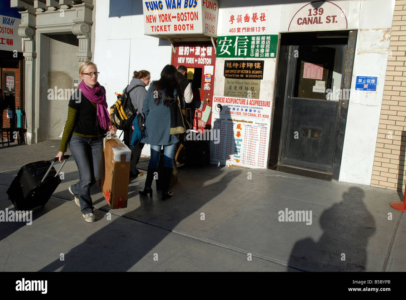 Travelers purchase bus tickets in New York in Chinatown Stock Photo