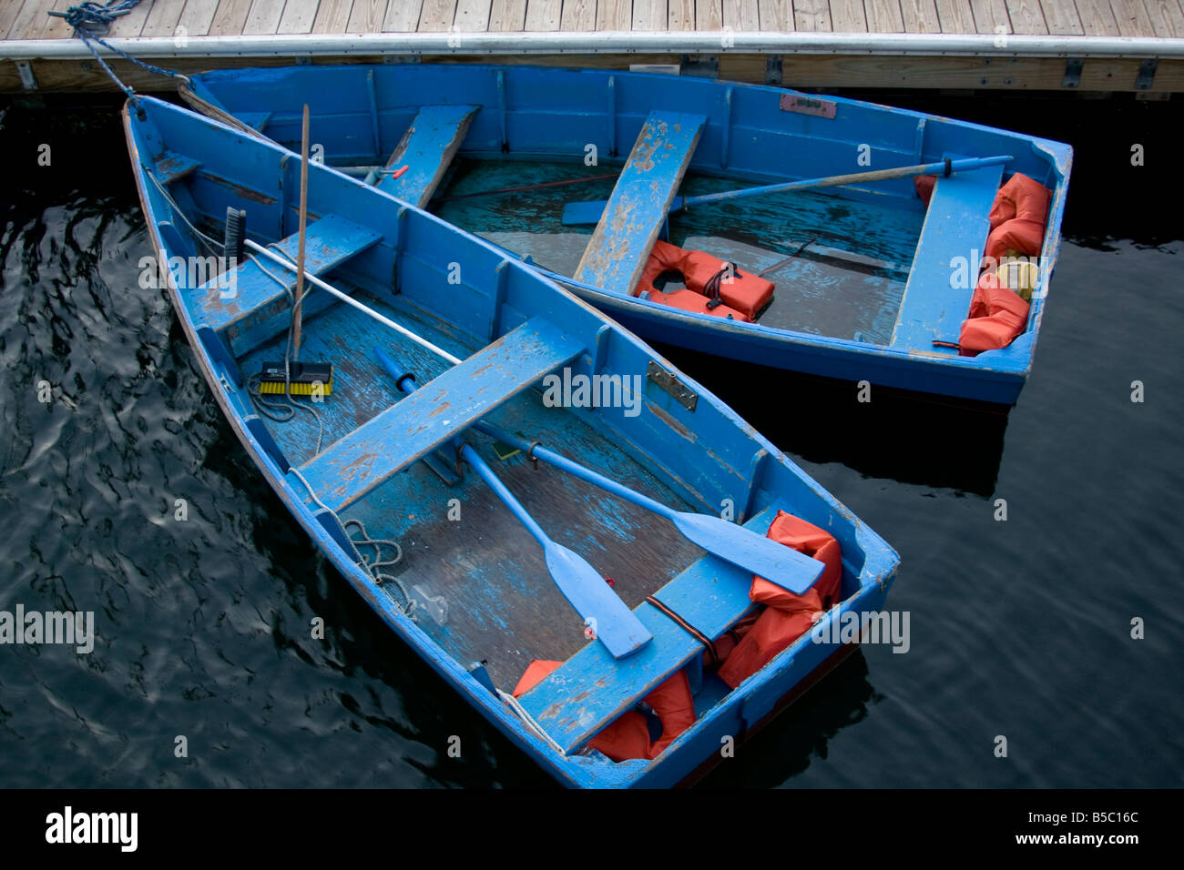 Blue Boats tied together at a dock. Stock Photo